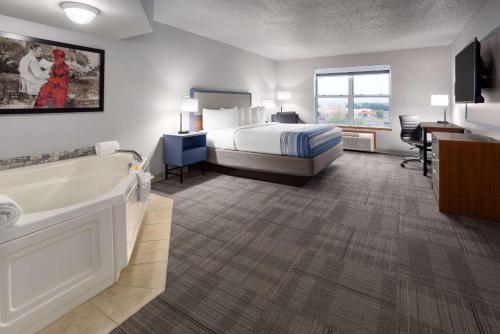 a hotel room with a bed and a bath tub at AmericInn by Wyndham Iron Mountain in Iron Mountain