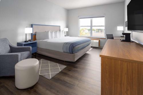 a hotel room with a bed and a flat screen tv at AmericInn by Wyndham Iron Mountain in Iron Mountain