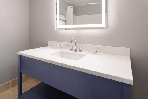 a bathroom with a white sink and a mirror at AmericInn by Wyndham Iron Mountain in Iron Mountain