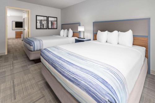 a hotel room with two beds and a television at AmericInn by Wyndham Iron Mountain in Iron Mountain