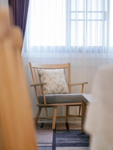 a chair with a pillow in front of a window at Click Residence, Si Muang in Vientiane