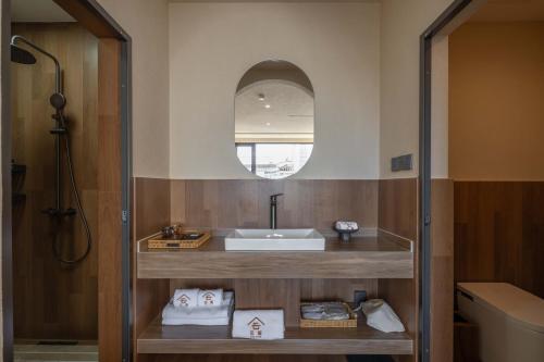 a bathroom with a sink and a mirror at Dali Lark View Private Hot Spring Hotel in Dali