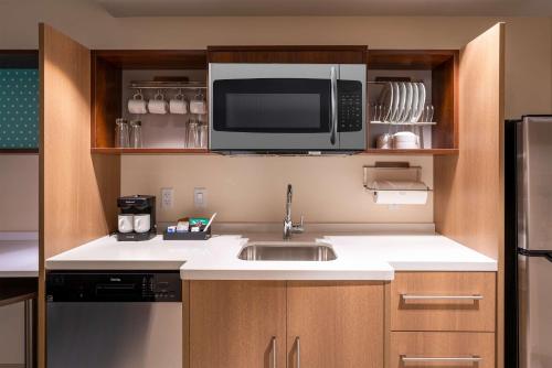a small kitchen with a sink and a microwave at Home2 Suites by Hilton Bozeman Midtown in Bozeman