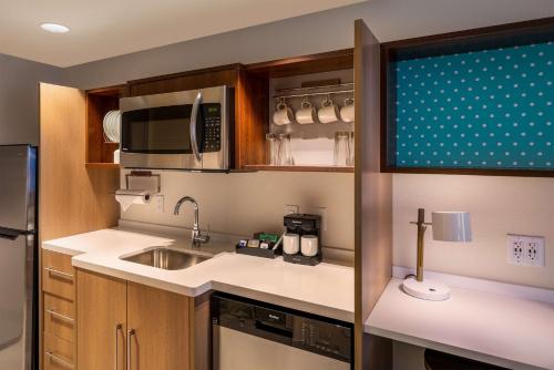 a small kitchen with a sink and a microwave at Home2 Suites by Hilton Bozeman Midtown in Bozeman