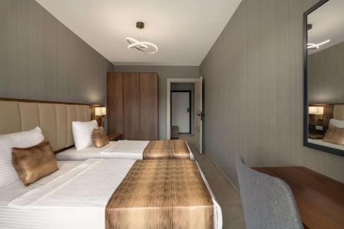 a hotel room with two beds and a table at Days Inn by Wyndham Alanya in Alanya