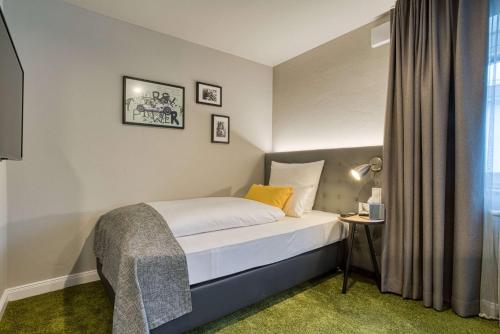 a hotel room with a bed and a window at Vienna House Easy by Wyndham Ingolstadt in Ingolstadt