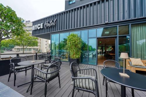 a patio with tables and chairs in front of a building at Vienna House Easy by Wyndham Hannover in Hannover