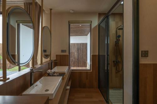 a bathroom with a sink and a shower and a mirror at Dali Lark View Private Hot Spring Hotel in Dali