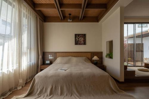 a bedroom with a bed and a large window at Dali Lark View Private Hot Spring Hotel in Dali