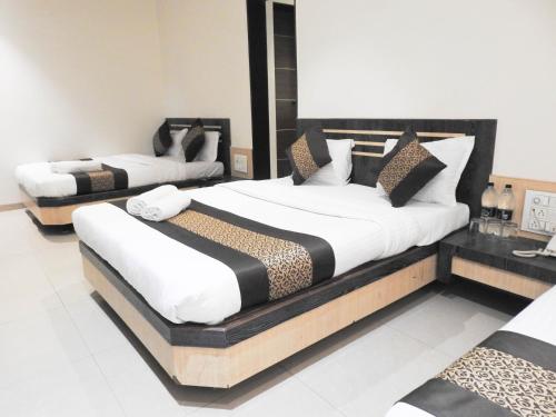 a bedroom with two beds in a room at HOTEL SAI VISHVA KARMA in Shirdi