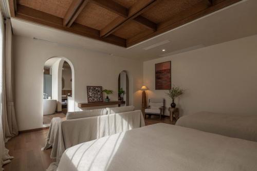 a bedroom with two beds and a living room at Dali Lark View Private Hot Spring Hotel in Dali