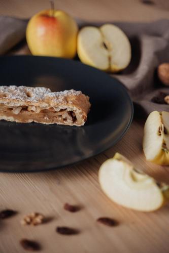 a black plate with a piece of apple pie on a table at Pimont Alpine Chalet in Madonna di Campiglio