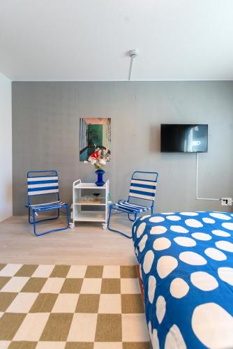 a bedroom with two blue chairs and a bed at Mi-HOTEL OTSUKA in Tokyo