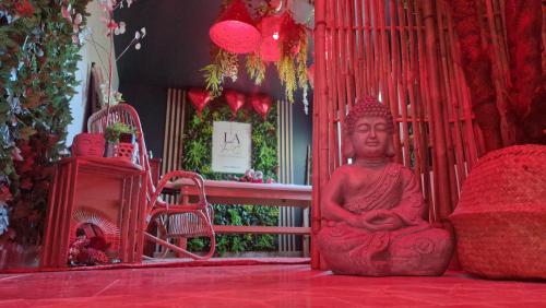 une grande statue rouge assise au sol dans une pièce dans l'établissement La Love - Love room Marseille, à Marseille