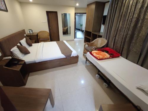 a hotel room with two beds and a table at SWAGATAM INN, 5 minutes walk from Guwahati Railway Station in Guwahati