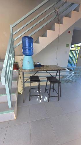a table and two stools in a room with a stairs at Villa Juan y Exequila in Anda