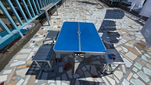 a blue picnic table and two benches on a sidewalk at Villa Juan y Exequila in Anda
