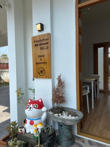 a front door of a house with a plant at Baan Marukome Chiang Rai บ้านมารุโกเมะ เชียงราย in Ban Pa Yang (3)