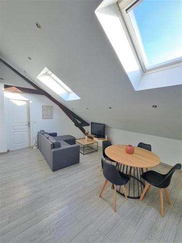 un salon avec une table et un canapé dans l'établissement Landria Home - appartement 1 chambre proche de la Gare de reims centre, à Reims