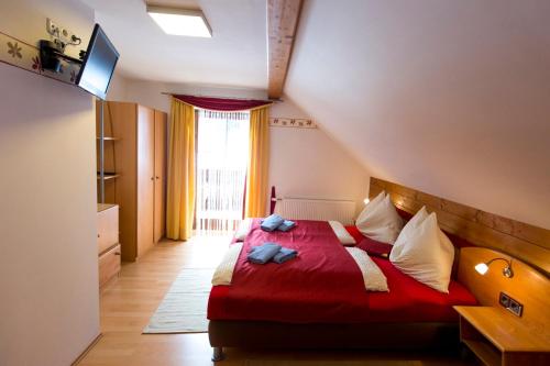 a bedroom with a red bed and a window at Gästehaus Biobauernhof Mandl in Murau