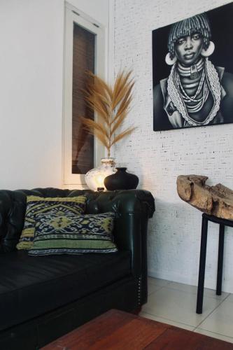 a living room with a black couch and a picture of a woman at Dwipa Peaceful, spacious 2 bedroom villa in Sanur