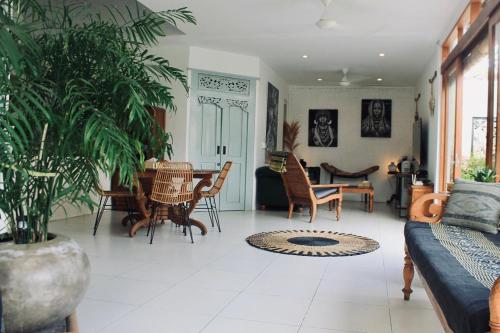 a living room with a couch and a table and chairs at Dwipa Peaceful, spacious 2 bedroom villa in Sanur