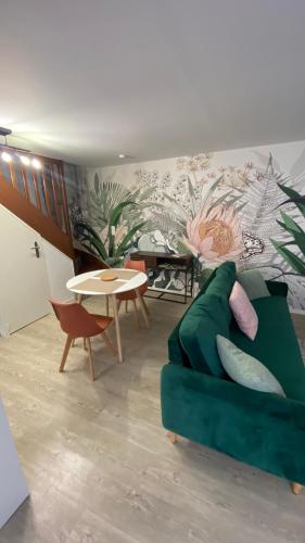 un salon avec un canapé vert et une table dans l'établissement La Léonard île au coeur de l île d or logement avec chambre climatisée, à Amboise