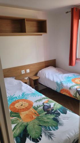 - une chambre avec 2 lits avec un singe dans l'établissement Mobil home 40 m2 Grand Confort, à Pont-Aven