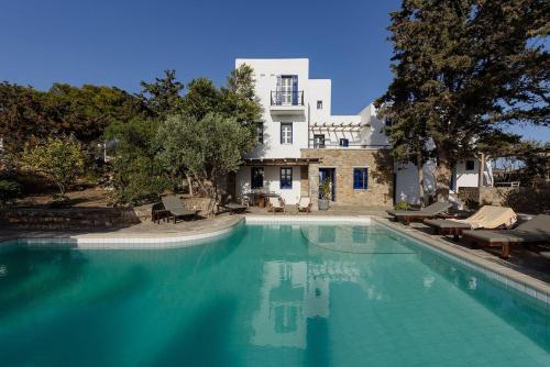 a large swimming pool in front of a house at Villa Padma, Agkeria Paros in Angairiá