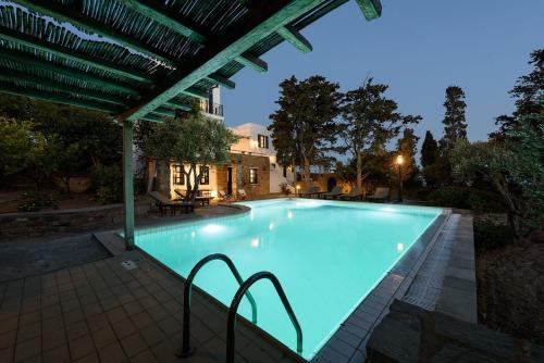 a large swimming pool at night with a pergola at Villa Padma, Agkeria Paros in Angairiá