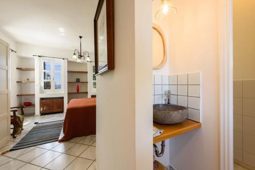a bathroom with a sink and a bedroom at Villa Padma, Agkeria Paros in Angairiá