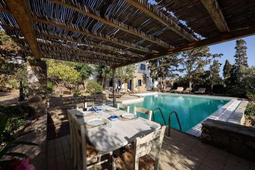 a patio with a table and a swimming pool at Villa Padma, Agkeria Paros in Angairiá