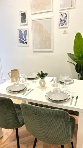 une table de salle à manger avec des assiettes et des verres dessus dans l'établissement Appartement Haussmannien Gare Centre-ville Clim, à Montpellier