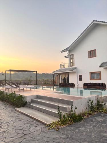 a villa with a swimming pool and a house at Baan Marukome Chiang Rai บ้านมารุโกเมะ เชียงราย in Ban Pa Yang (3)