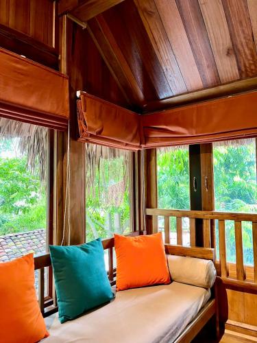 a bench with colorful pillows sitting in a room at Hang Mua Ecolodge in Ninh Binh