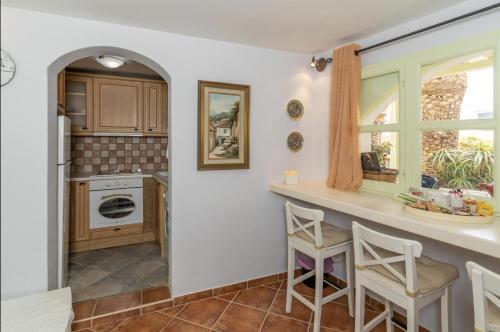 a kitchen with a counter and two stools at Villa Ostria in Koufonisia