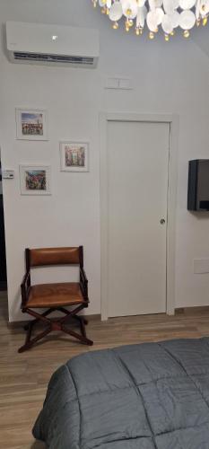 a bedroom with a chair next to a door at Campanile 17 in Manfredonia