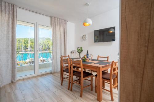 a dining room with a table and chairs and a balcony at Seafront Stone Home With King Beds, Garden And Balcony in Stari Grad