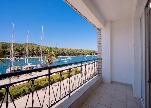 a balcony with a view of a marina at Seafront Stone Home With King Beds, Garden And Balcony in Stari Grad
