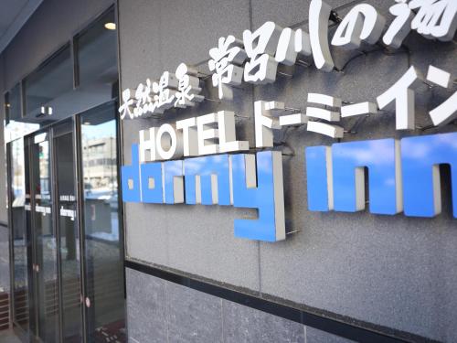 a hotel sign on the side of a building at Dormy Inn Kitami in Kitami