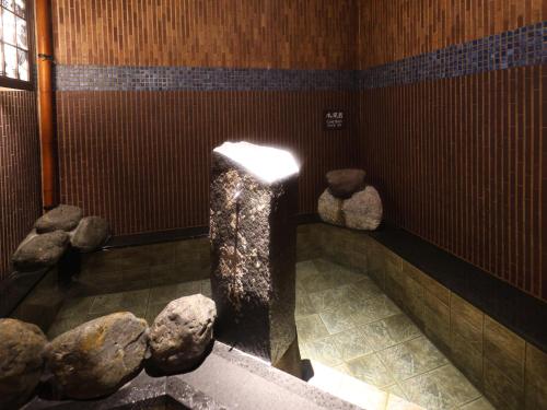 a room with rocks on the floor of a building at Dormy Inn Kitami in Kitami