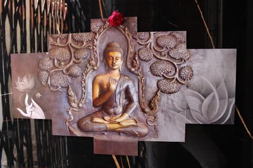 a wooden statue of a buddha on a wall at Babu naidu residency BNR in Vellore