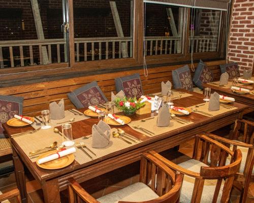 a long wooden table with chairs and plates of food at Basera Boutique Hotel in Kathmandu