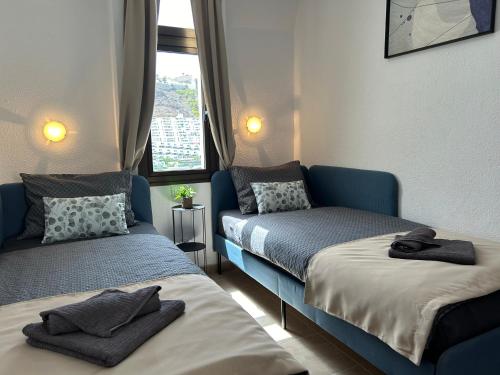 a room with two beds and a window at Sunny Monaco Puerto Rico in Mogán