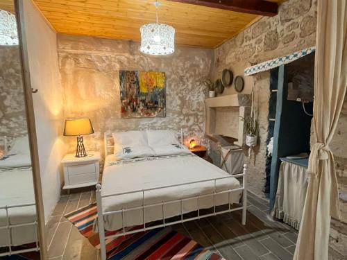 Un dormitorio con una cama y una pared de piedra. en esket alaçatı, en Alacati