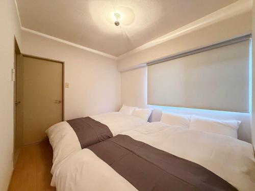 Ένα ή περισσότερα κρεβάτια σε δωμάτιο στο Residence Yu - Spacious 2BR Apartment Central Yet Peaceful Stay