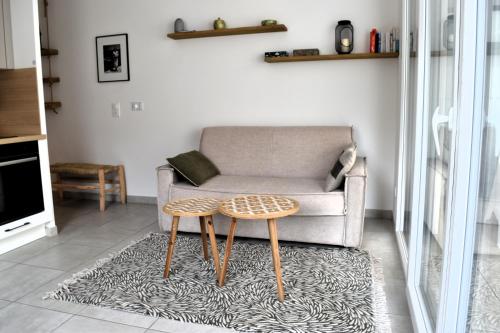 un salon avec un canapé et une table dans l'établissement Apt confortable avec terrasse et parking, à Sète