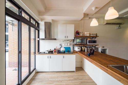 a kitchen with white cabinets and a large window at Dongshan Yi Hostel in Dongshan