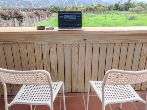 two white chairs and a laptop sitting on a counter at Dongshan Yi Hostel in Dongshan