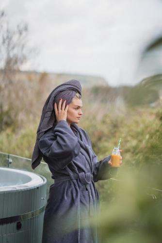 a woman in a robe holding a drink at Summerhill House Hotel in Enniskerry